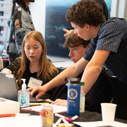 Students working together on a laptop during the hackathon