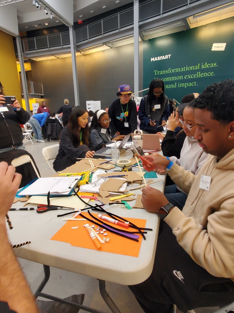 Teams prototyping with craft materials at a shared table